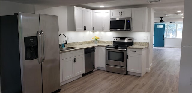 kitchen featuring ceiling fan, white cabinets, stainless steel appliances, and sink