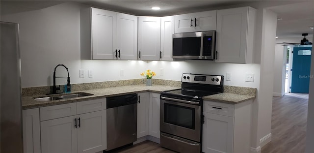 kitchen featuring ceiling fan, white cabinets, stainless steel appliances, and sink