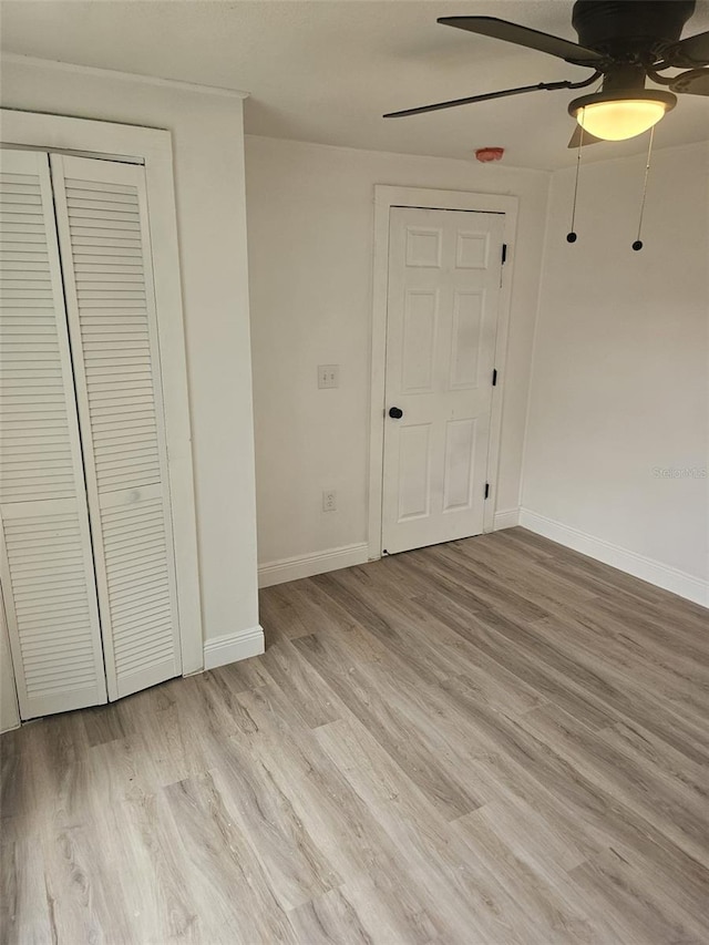 unfurnished bedroom with light hardwood / wood-style flooring, a closet, and ceiling fan