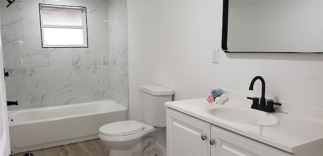 full bathroom with wood-type flooring, tiled shower / bath, vanity, and toilet