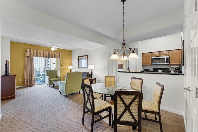 carpeted dining space with ceiling fan with notable chandelier