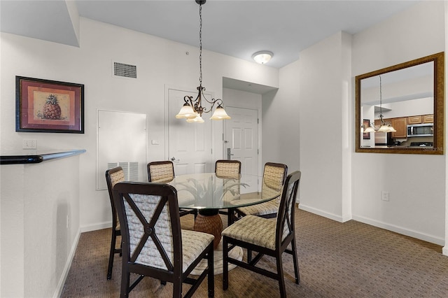 carpeted dining space with an inviting chandelier