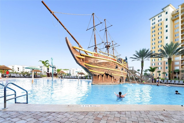 view of pool with a water slide and pool water feature