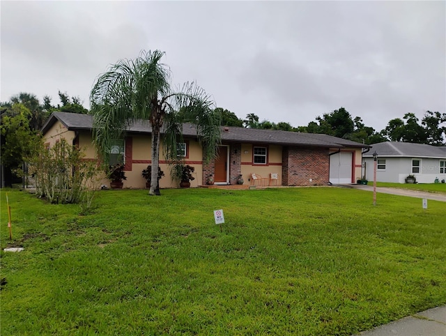 single story home featuring a front lawn and a garage