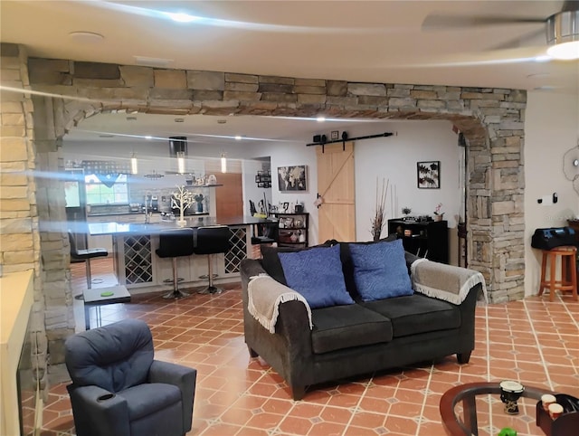 tiled living room with a barn door and bar area