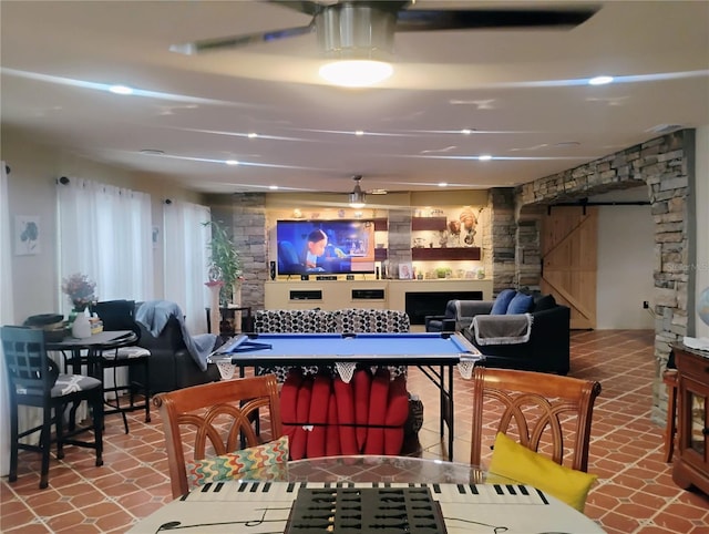 playroom featuring ceiling fan and a barn door