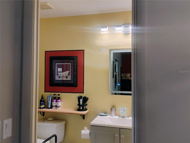 bathroom featuring vanity and toilet