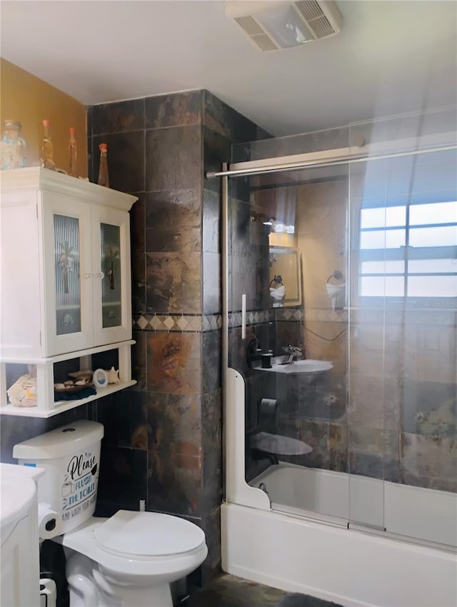 full bathroom with toilet, vanity, and combined bath / shower with glass door