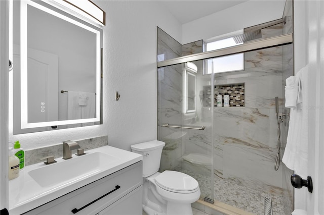 bathroom featuring vanity, toilet, and an enclosed shower