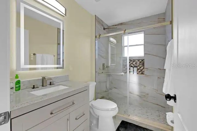 bathroom featuring vanity, toilet, and walk in shower