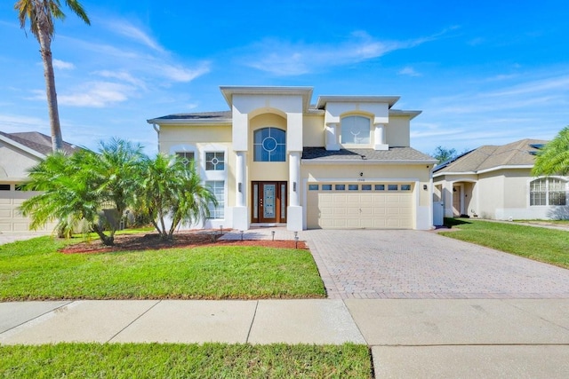 mediterranean / spanish-style house with a garage and a front lawn