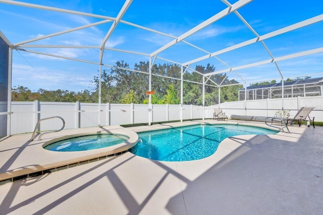 view of swimming pool featuring an in ground hot tub, a patio area, and glass enclosure