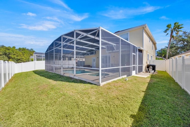 back of property with a fenced in pool, a lanai, a patio, and a lawn