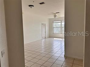 tiled empty room with ceiling fan