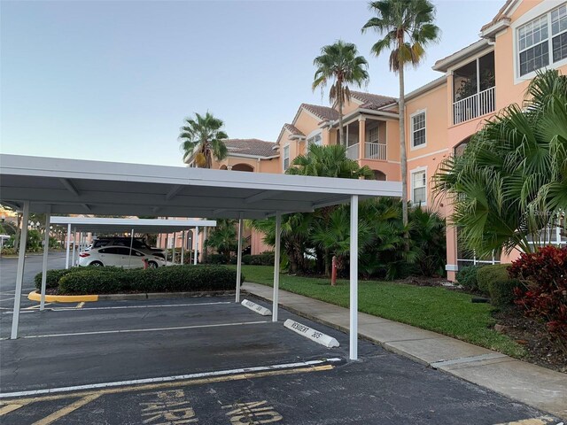 view of parking with a yard and a carport