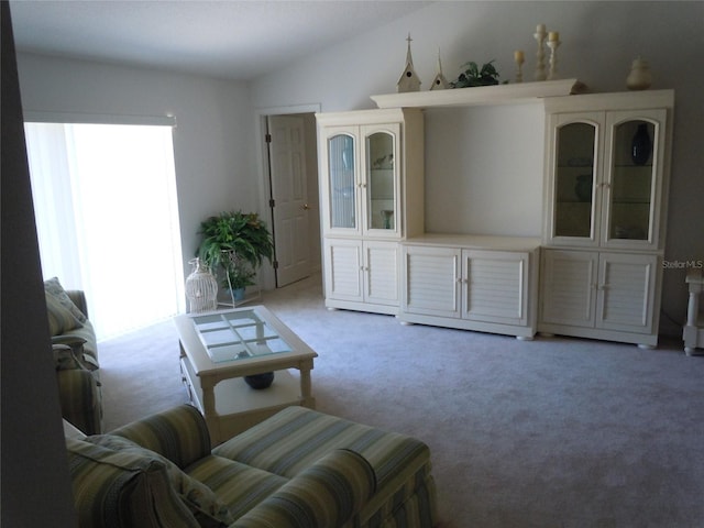 carpeted living room with lofted ceiling