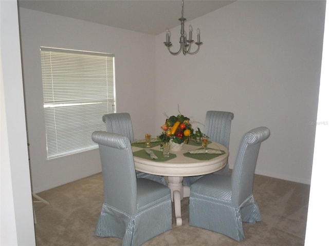 carpeted dining room featuring an inviting chandelier