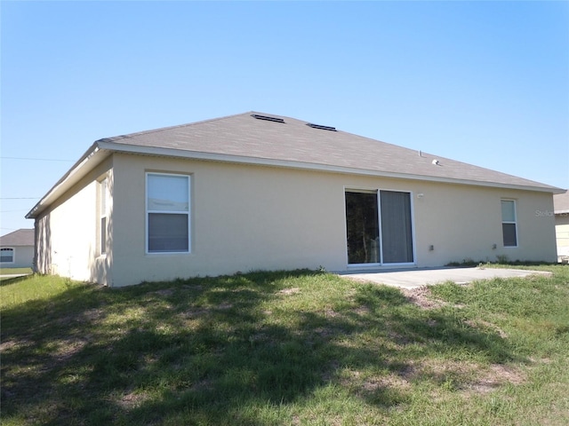 back of house with a patio area and a yard