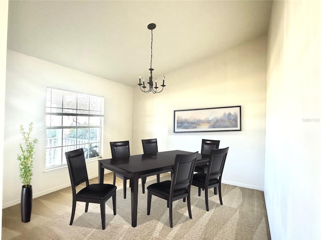 carpeted dining space featuring baseboards, a notable chandelier, and vaulted ceiling