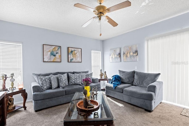 living area featuring ceiling fan, baseboards, carpet floors, and a textured ceiling