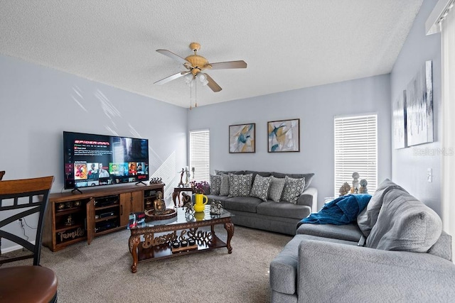 carpeted living area featuring a textured ceiling and a ceiling fan