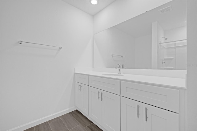 bathroom featuring hardwood / wood-style floors, vanity, and walk in shower