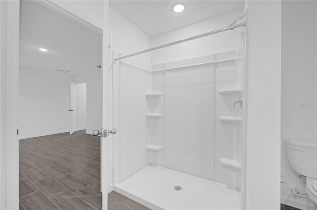 bathroom with walk in shower, wood-type flooring, and toilet