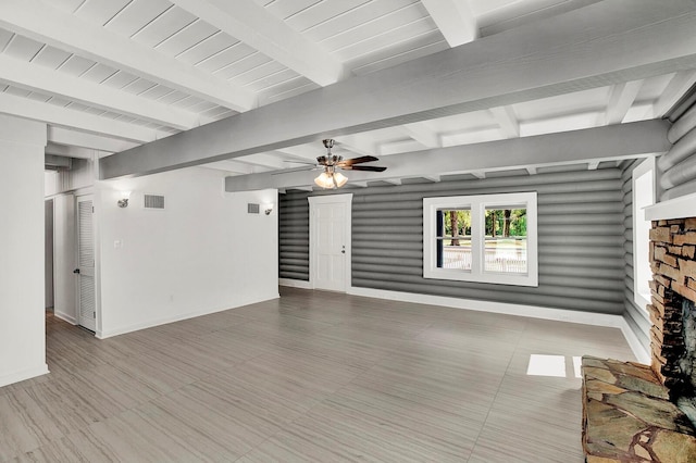 unfurnished living room with a fireplace, beam ceiling, and ceiling fan