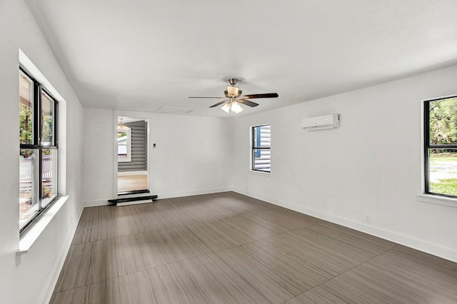 empty room with an AC wall unit, ceiling fan, and plenty of natural light