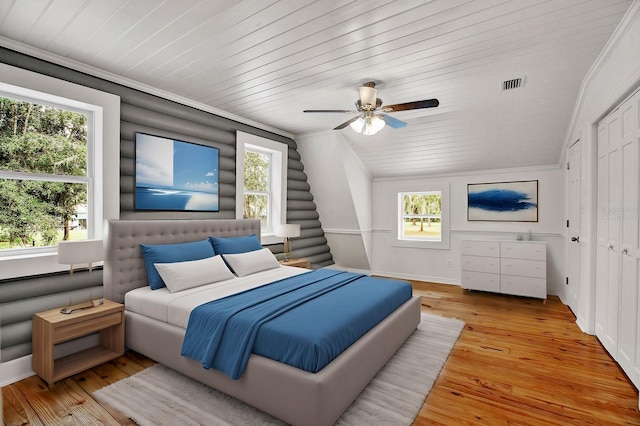 bedroom with ceiling fan, lofted ceiling, light wood-type flooring, and multiple windows