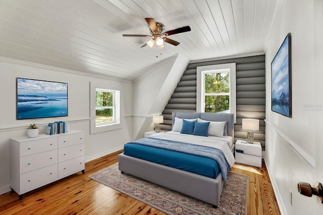 bedroom featuring multiple windows, lofted ceiling, ceiling fan, and light hardwood / wood-style flooring