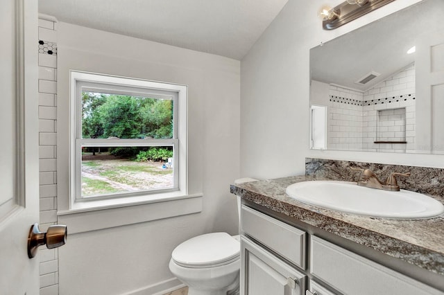 bathroom with vaulted ceiling, vanity, and toilet