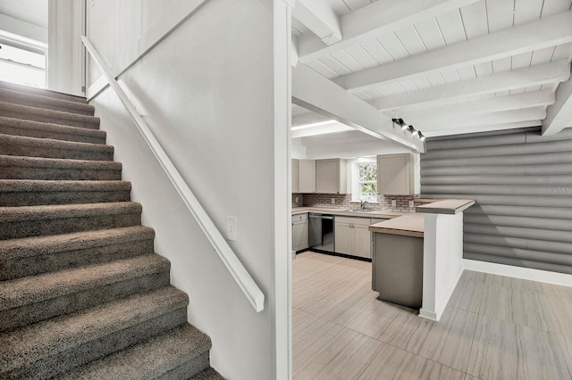 stairs with beam ceiling, tile patterned floors, and sink