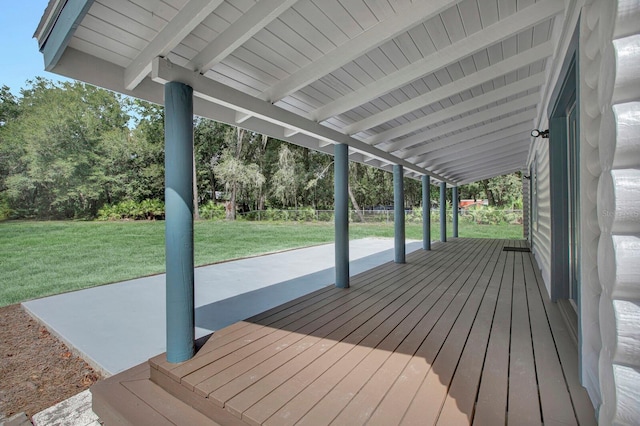 wooden terrace with a lawn and a patio area