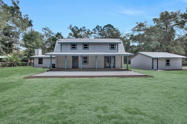 rear view of house featuring an outdoor structure and a yard