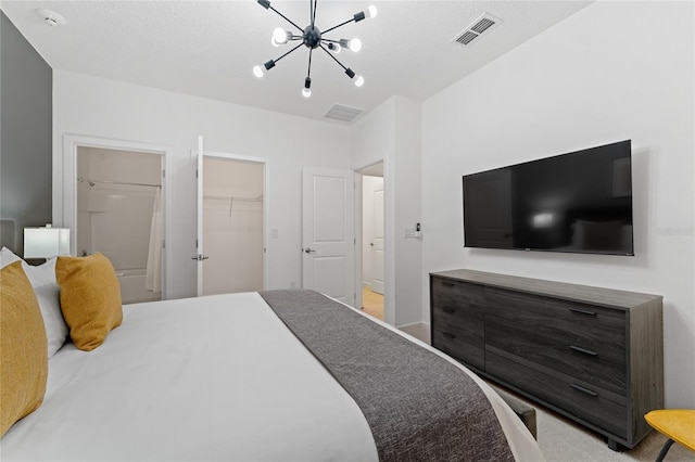 bedroom featuring a closet, a spacious closet, and a notable chandelier