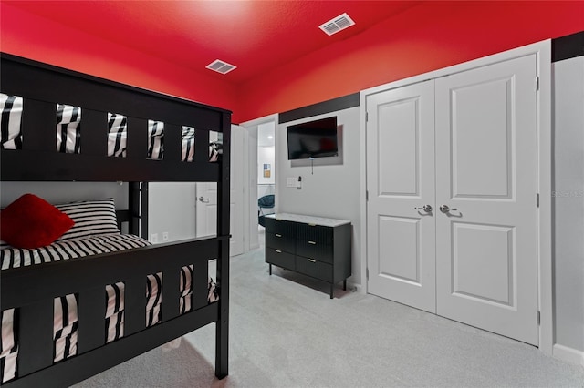 bedroom with light carpet and a closet