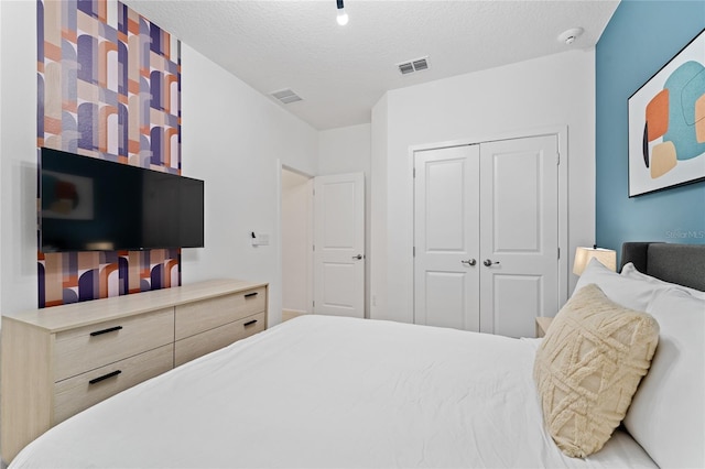 bedroom with a textured ceiling and a closet