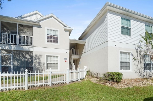 view of front of property with a front yard and a balcony