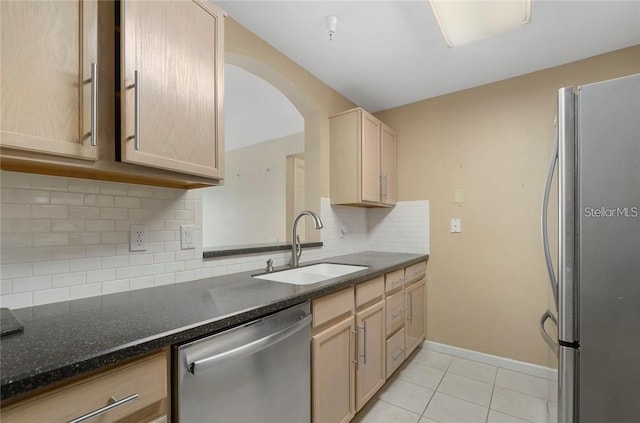 kitchen with light brown cabinets, backsplash, sink, and stainless steel appliances