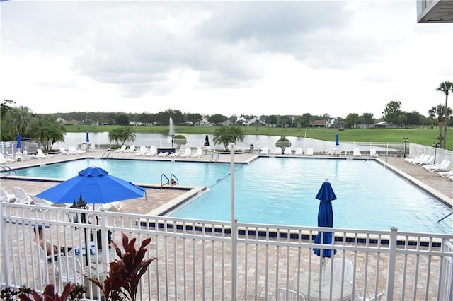 view of pool with a patio and a water view