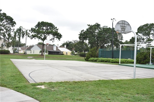 view of sport court with a lawn