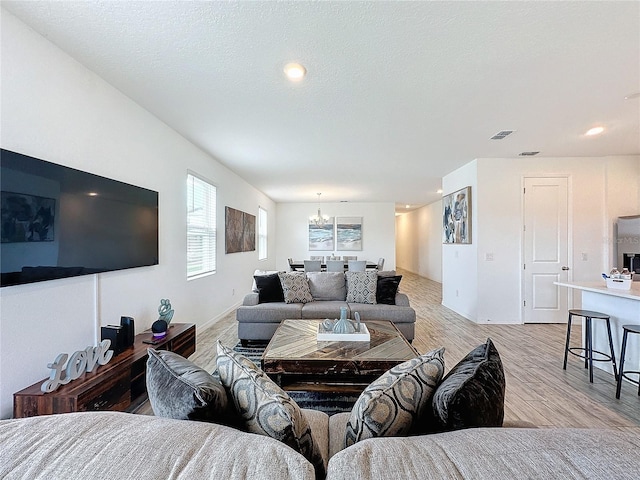 living room with light hardwood / wood-style flooring and a chandelier