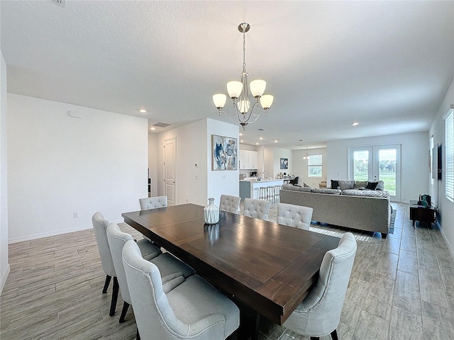 dining room featuring light wood-type flooring and a notable chandelier