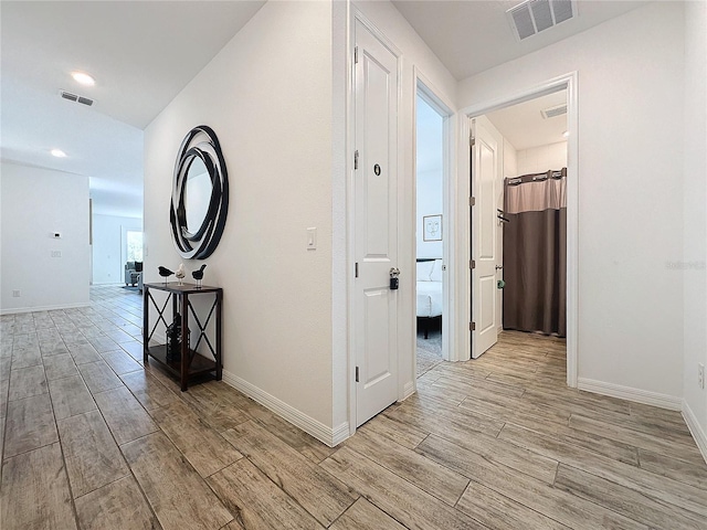 hallway with light hardwood / wood-style floors