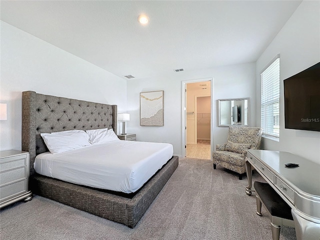 bedroom featuring carpet flooring and a walk in closet