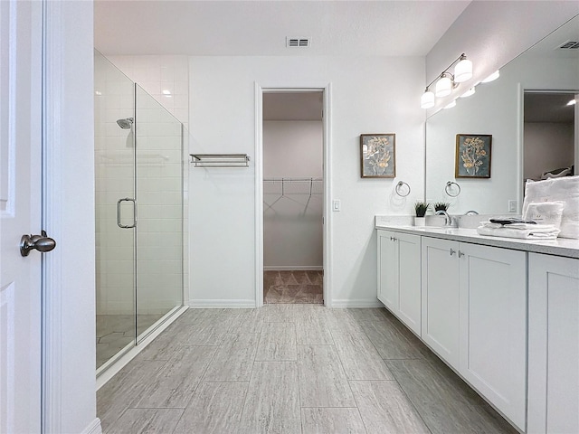 bathroom featuring walk in shower and vanity