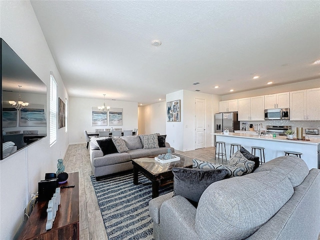 living room featuring a notable chandelier, sink, and hardwood / wood-style flooring