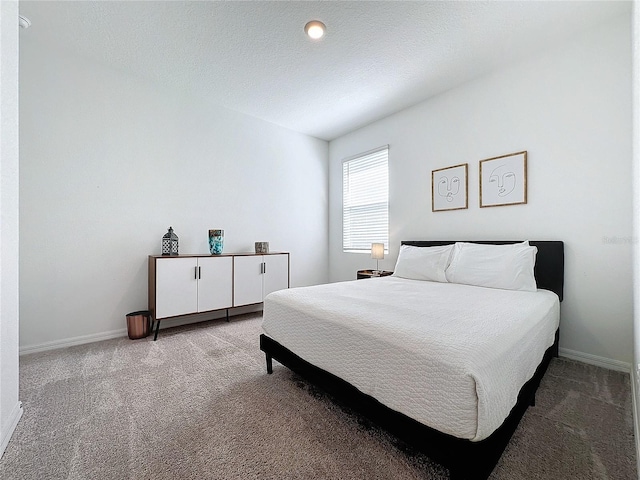 bedroom featuring light carpet and a textured ceiling