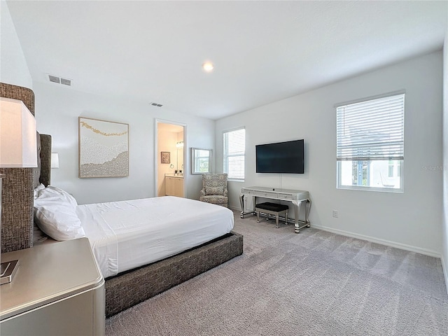 bedroom with light carpet and ensuite bathroom